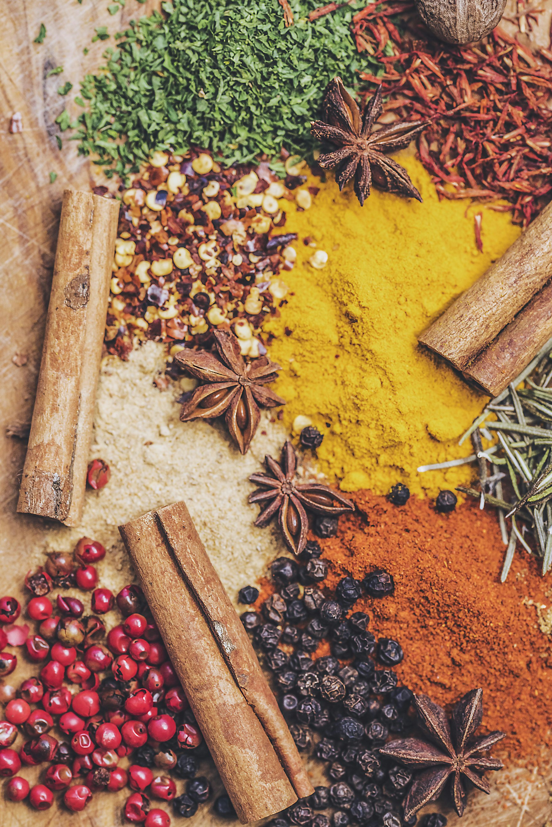 A spread of colourful spices on a wooden board